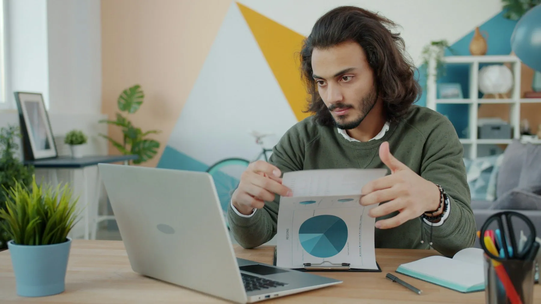 A founder reviewing a printed chart next to his laptop