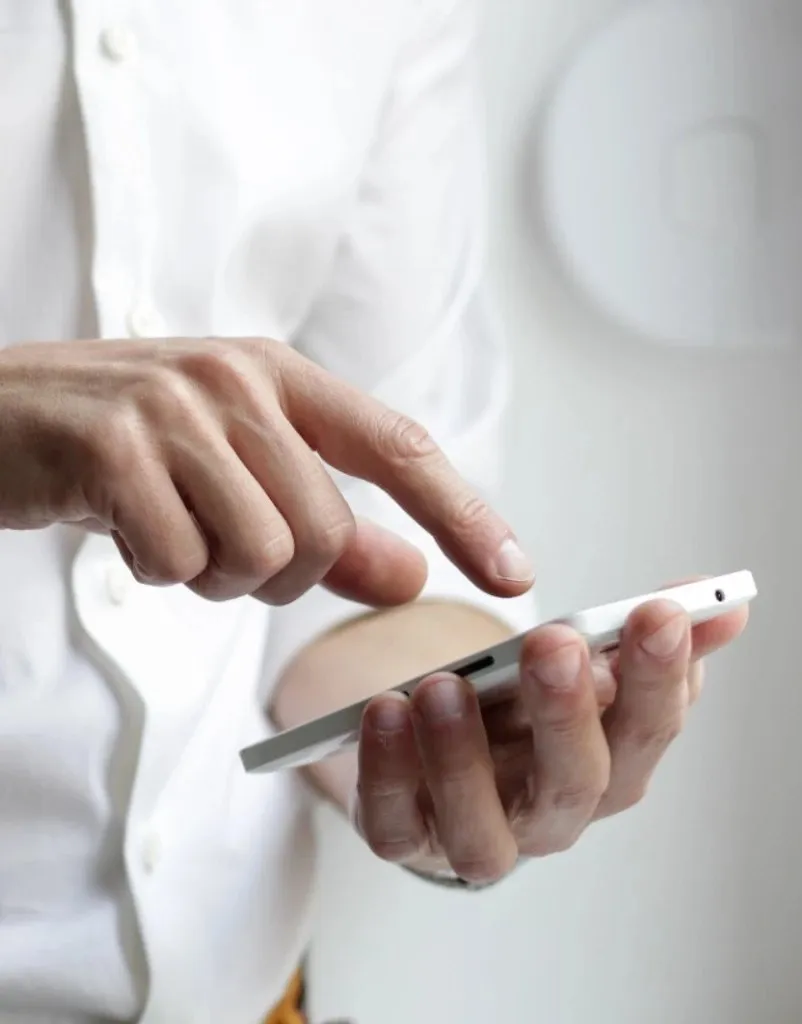 A person in a white shirt paying with the Digipay app on a phone